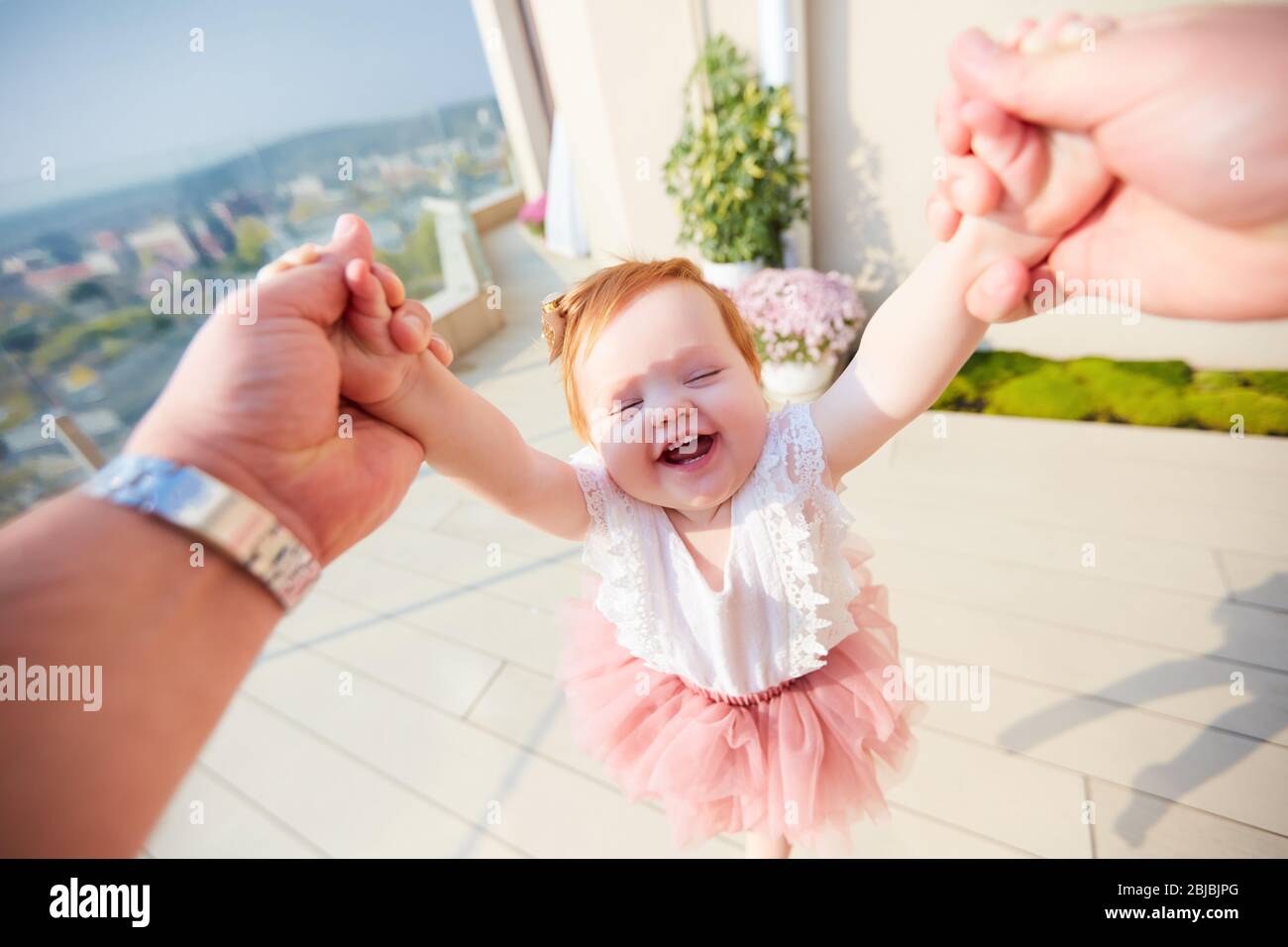 happy infant baby girl is spinning in a circle by father, family time