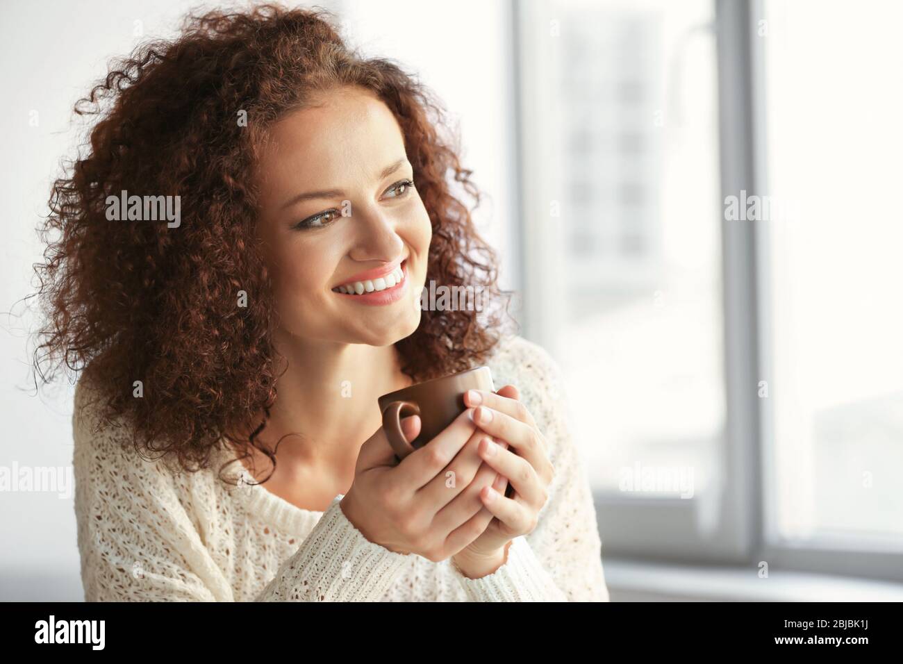Portrait of young beautiful woman holding cup of coffee Stock Photo - Alamy
