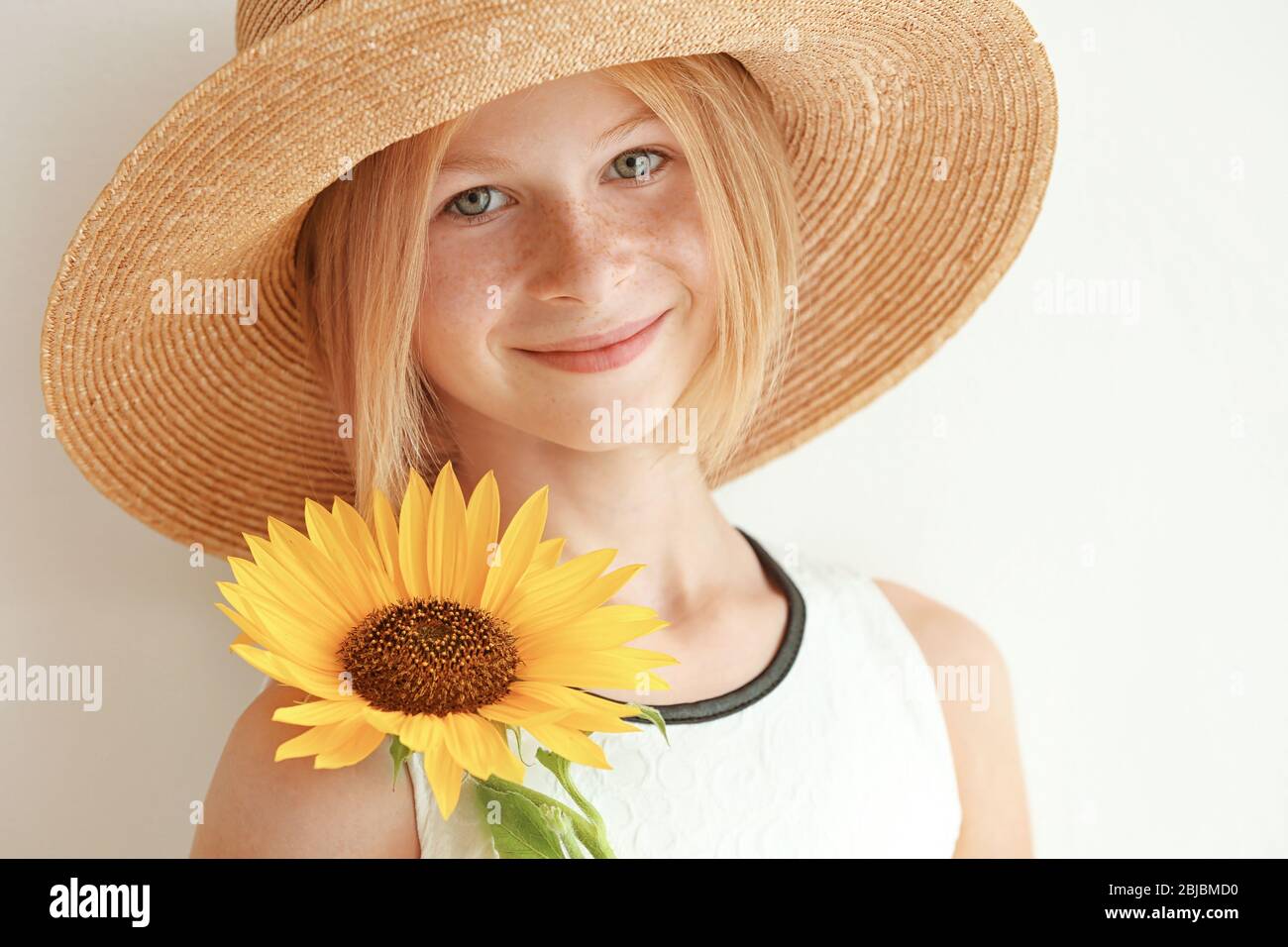 Portrait of attractive girl in straw hat with sunflower on white ...