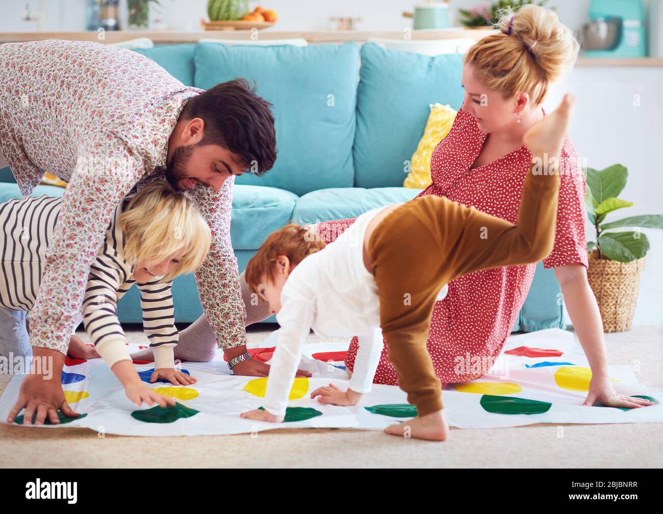 happy family having fun together, playing twister game at home Stock Photo