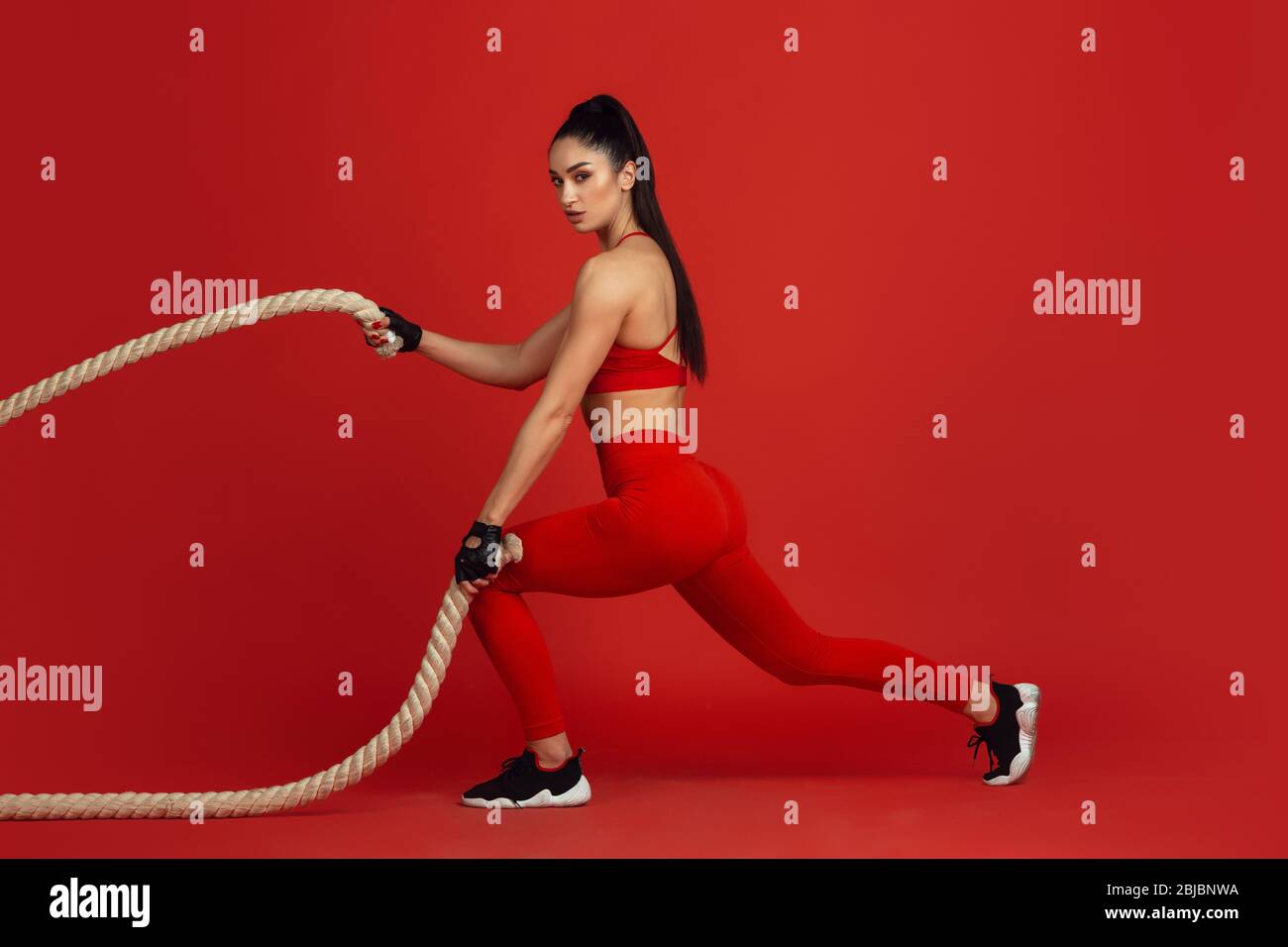 Training active. Beautiful young female athlete practicing in studio ...