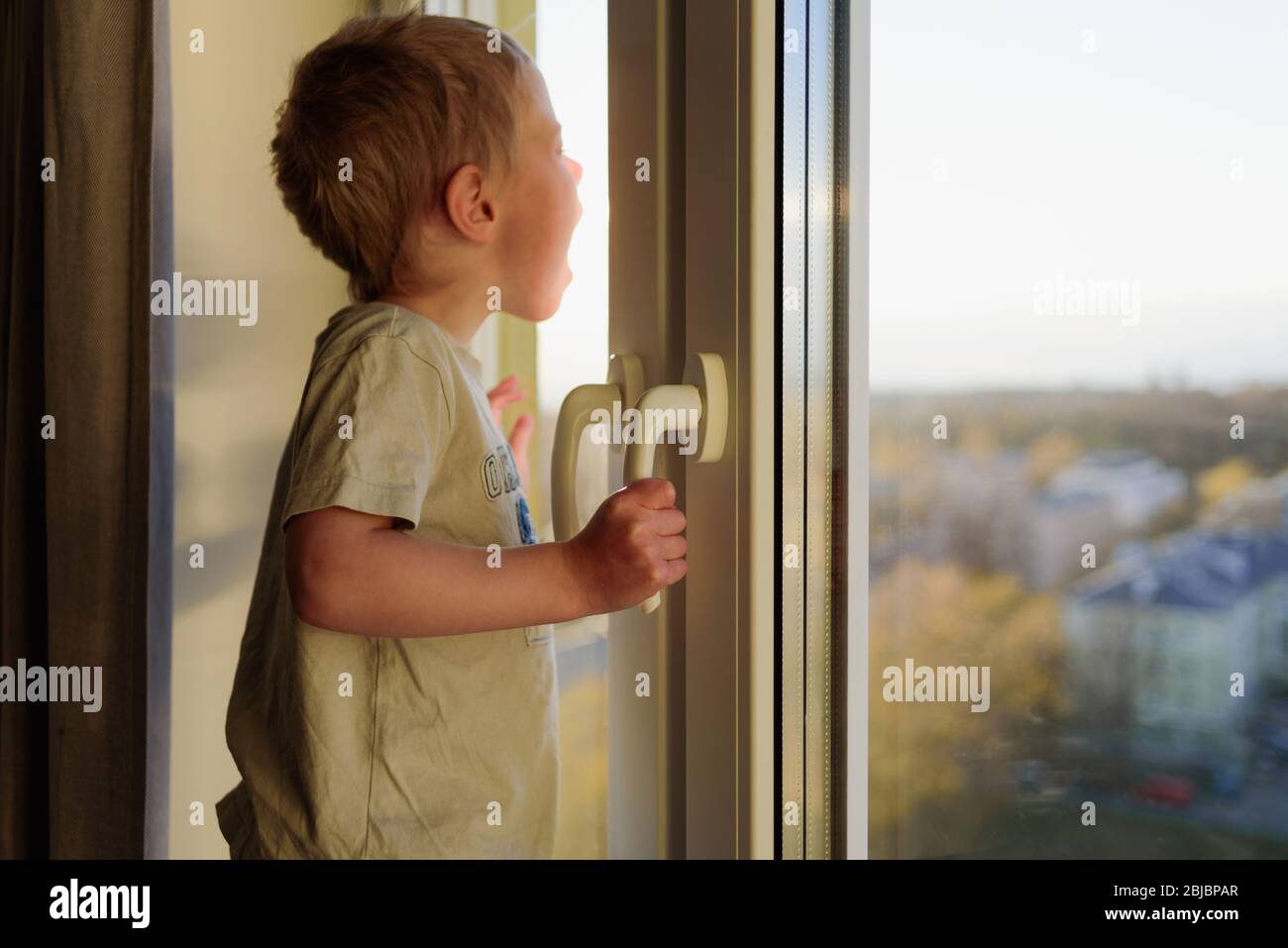 Boy shouting through window. Child opening window without parents ...