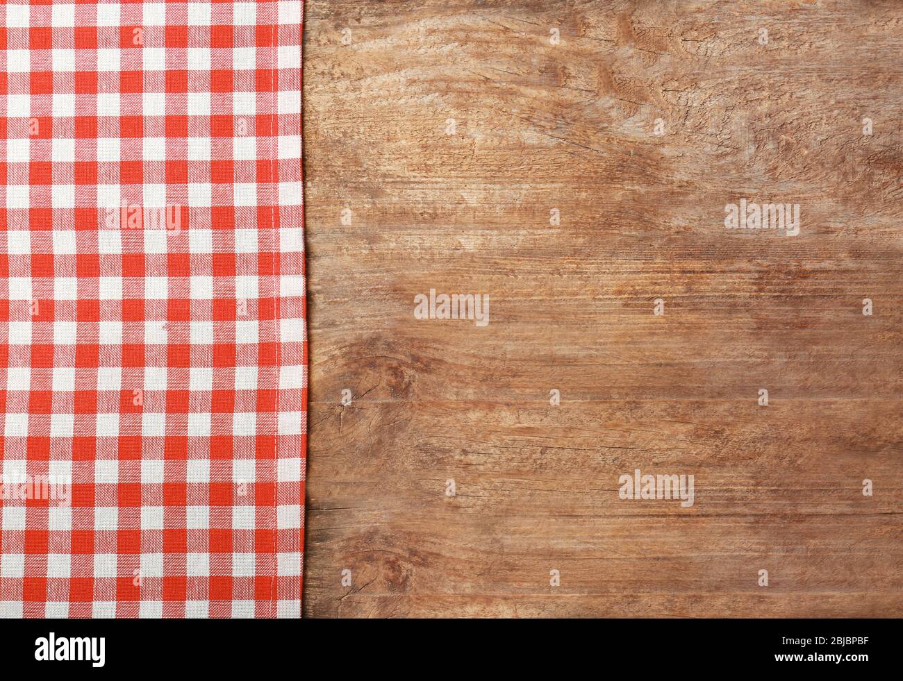 Red checkered tablecloth on wooden background Stock Photo