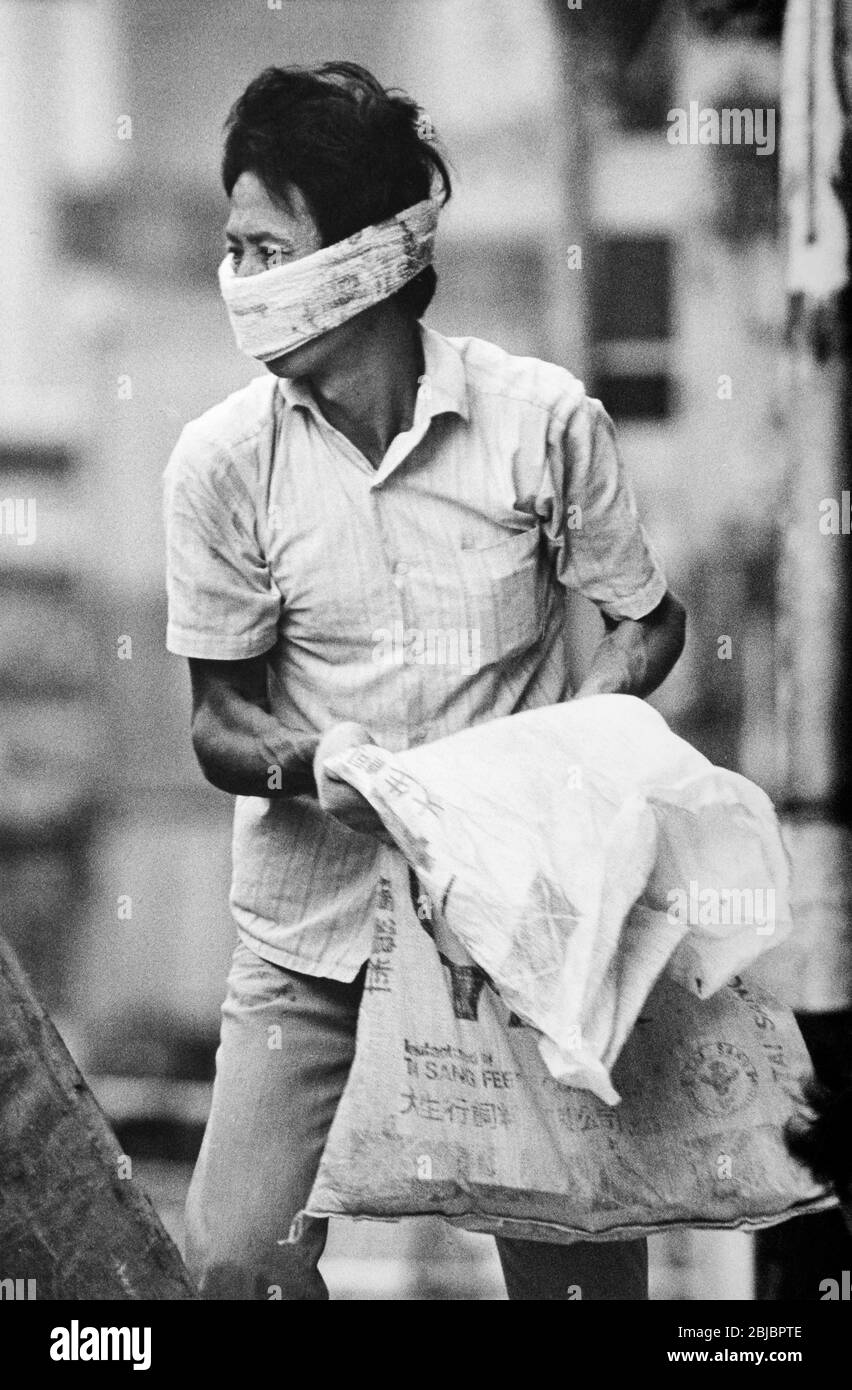 Hong Kong October 1986 Builder unloading cement at a building site in Connaught Road. The picture is is part of a collection of photographs taken in Hong Kong between September and November, 1986. They represent a snapshot of Daily Life in the Crown Colony eleven years before sovereignty was transferred back to mainland China. Photograph by Howard Walker / Alamy. Stock Photo