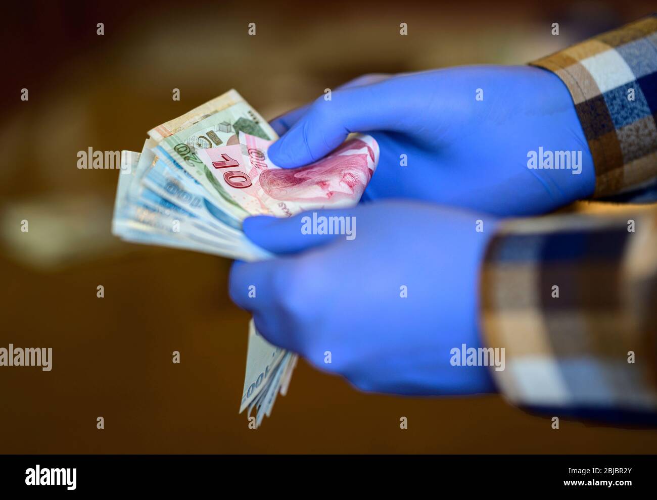 blue gloved hand counting money, corona concept. Stock Photo