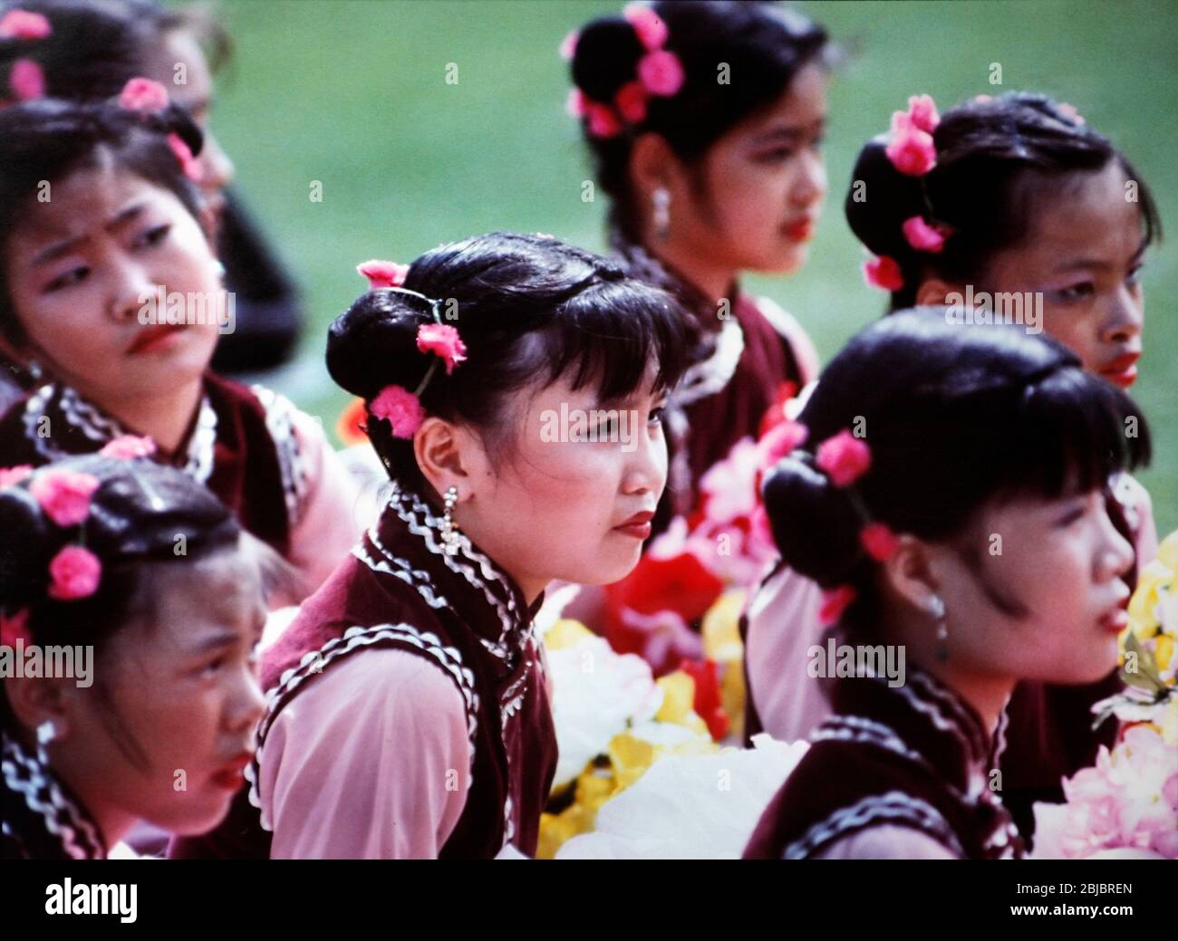 Hong Kong October 1986 Girls in tradition Chinese costume wait patiently to perform for The Queen during he Royal Visit. The picture is is part of a collection of photographs taken in Hong Kong between September and November, 1986. They represent a snapshot of Daily Life in the Crown Colony eleven years before sovereignty was transferred back to mainland China. Photograph by Howard Walker / Alamy. Stock Photo