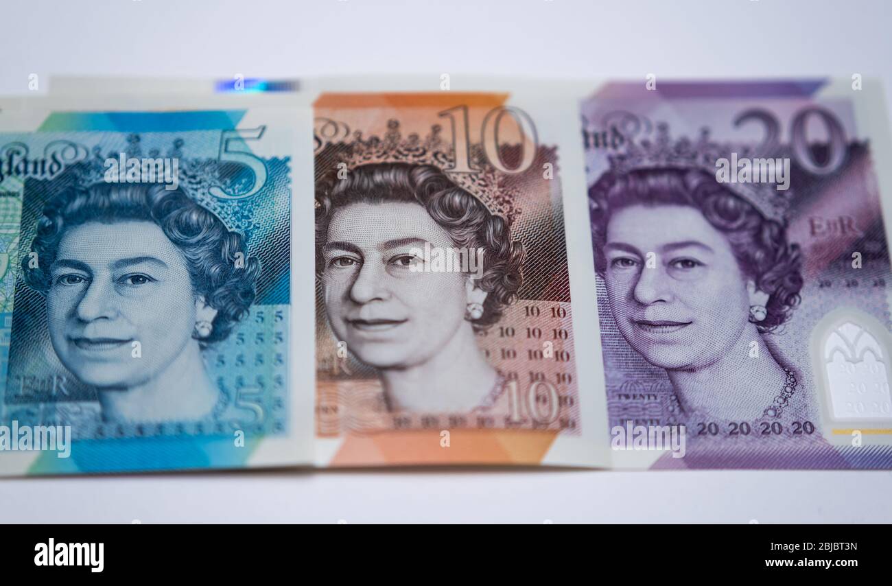 British pound sterlings polymer banknotes placed on each other. Photo includes a new 20 pound note released in February 2020. Close up. Stock Photo