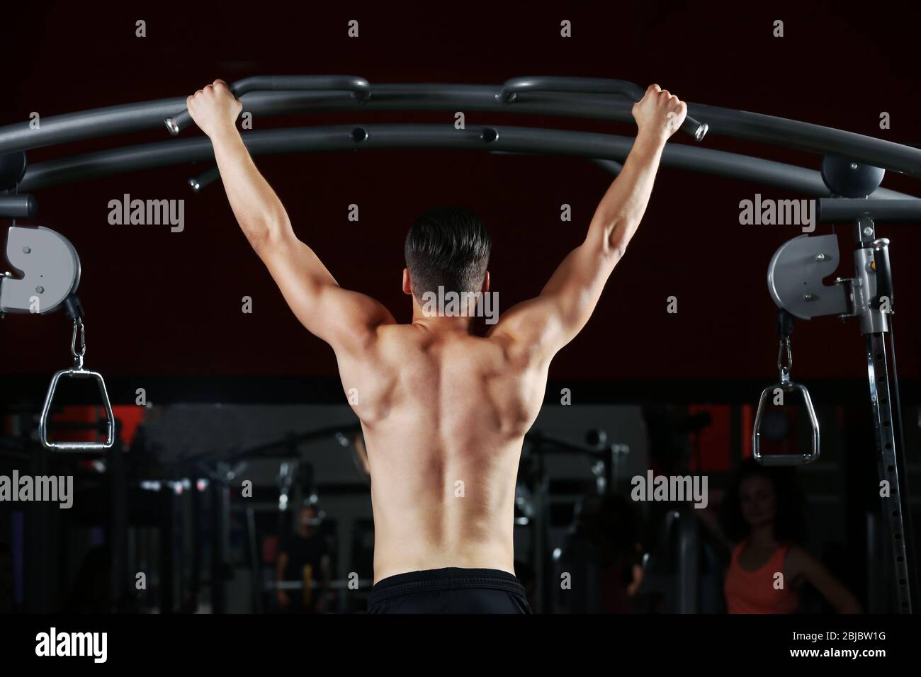Athletic man training back muscles in gym Stock Photo Alamy