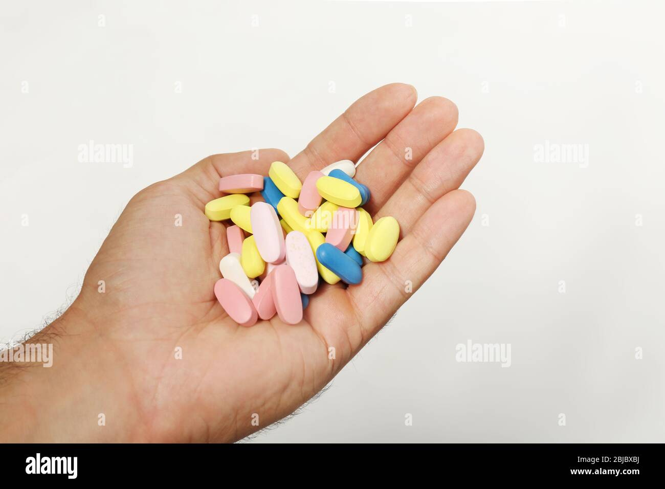 Male hand holding drugs on color background Stock Photo - Alamy