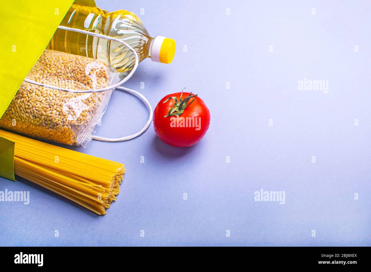 Food supplies for quarantine on lilac background. Pasta, vegetables, sunflower oil, cereals. Stock Photo