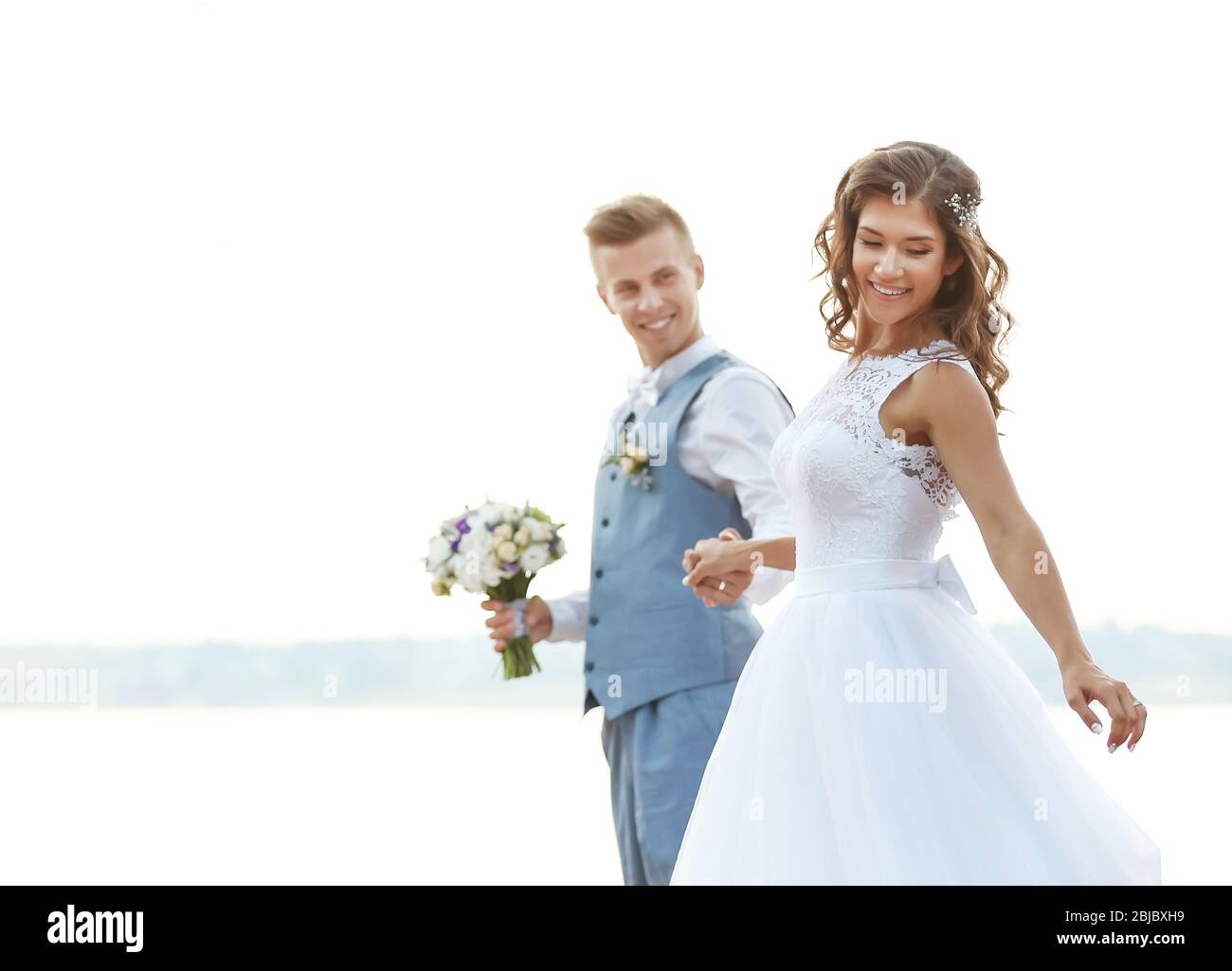 Beautiful wedding couple outdoors on light blurred background, close up view Stock Photo