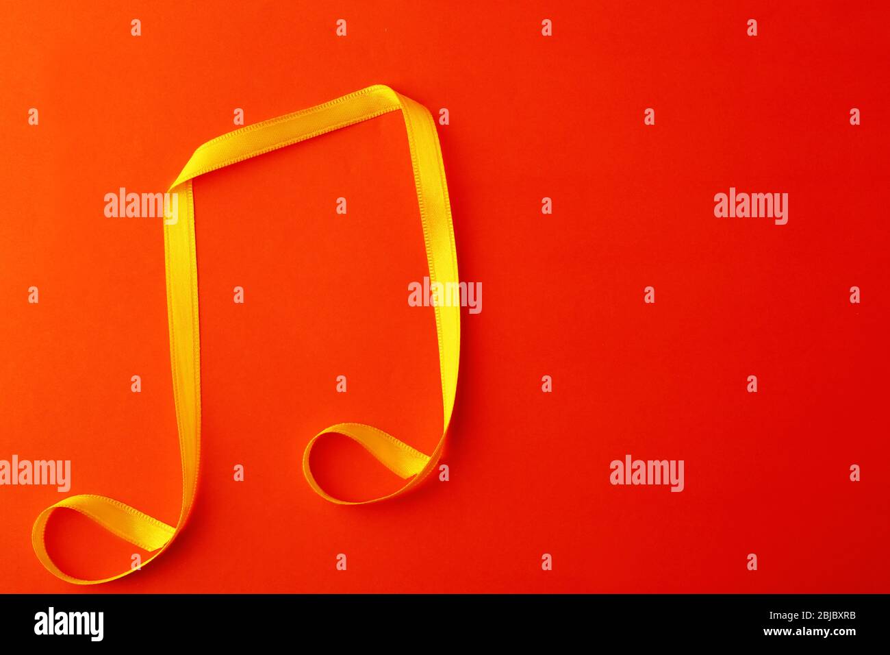 Musical note made of satin ribbon on color background Stock Photo - Alamy
