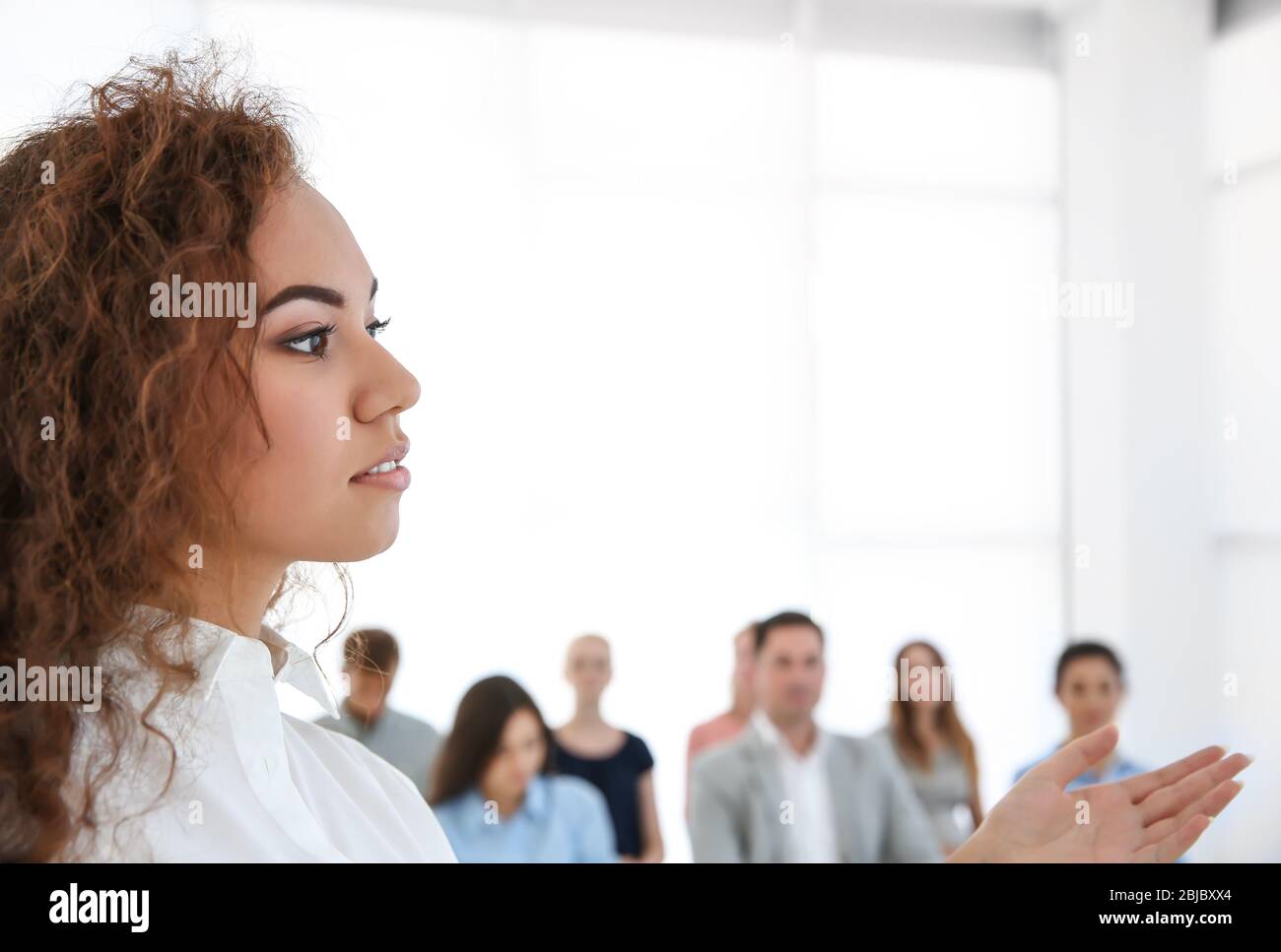Business trainer giving presentation to group of people Stock Photo - Alamy