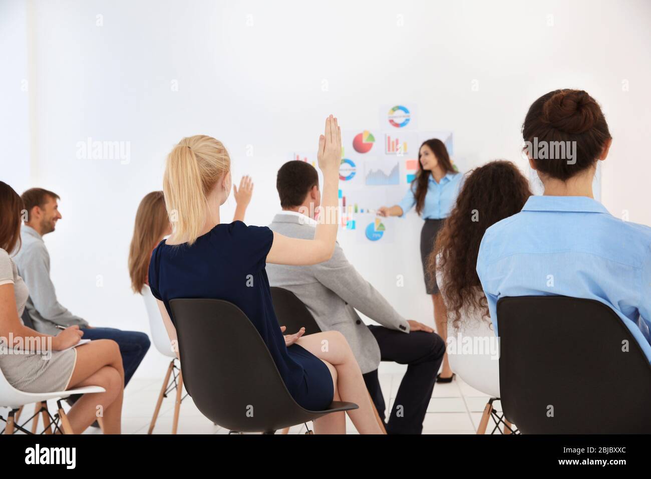Business trainer giving presentation to group of people Stock Photo - Alamy