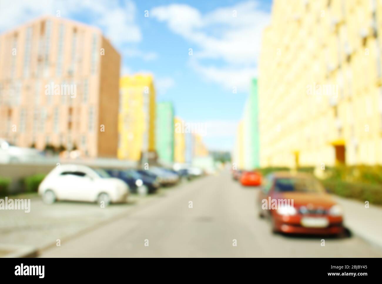 Blurred view of parked cars near modern colorful buildings Stock Photo ...