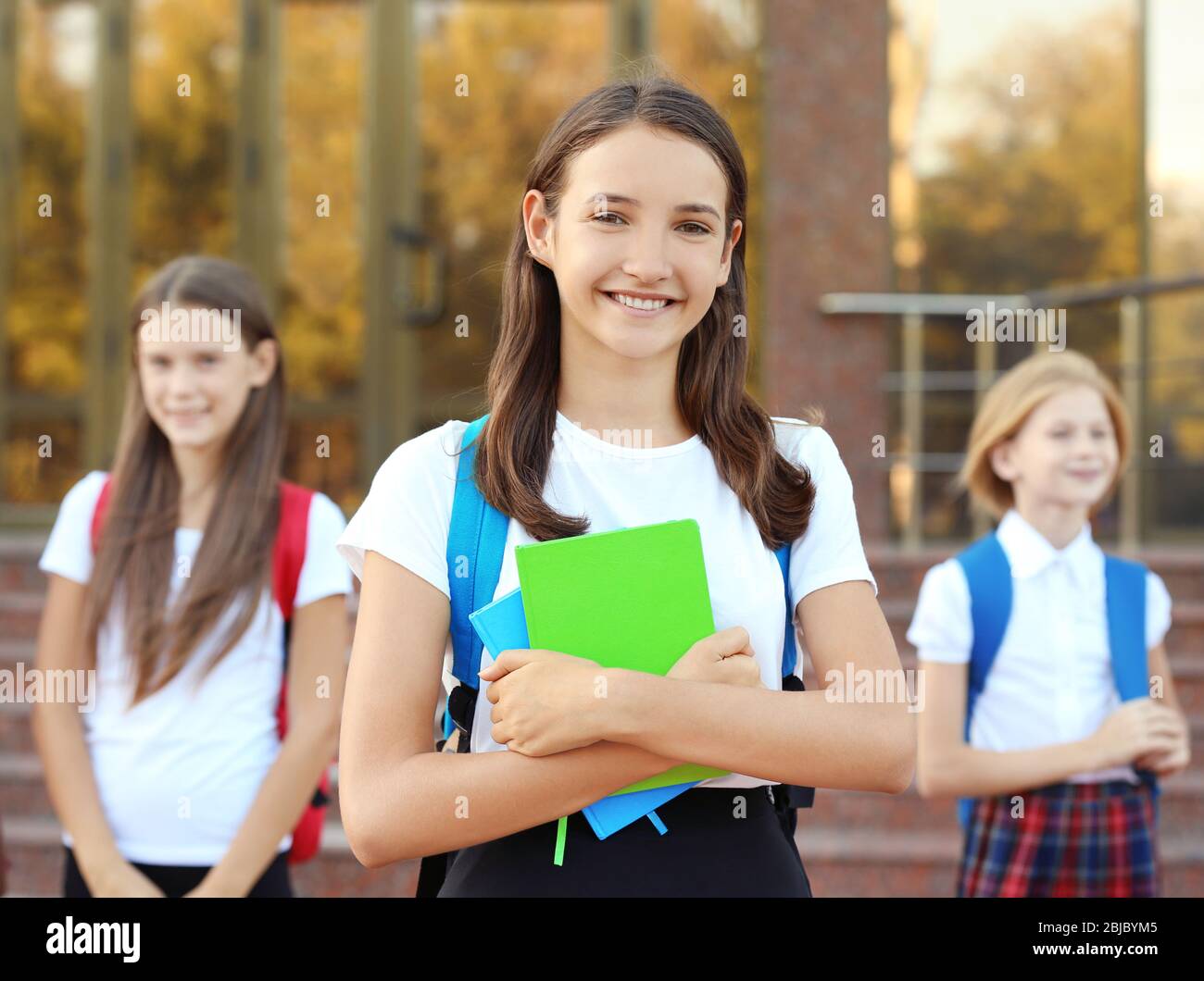 Teenage girl and her friends going to school Stock Photo