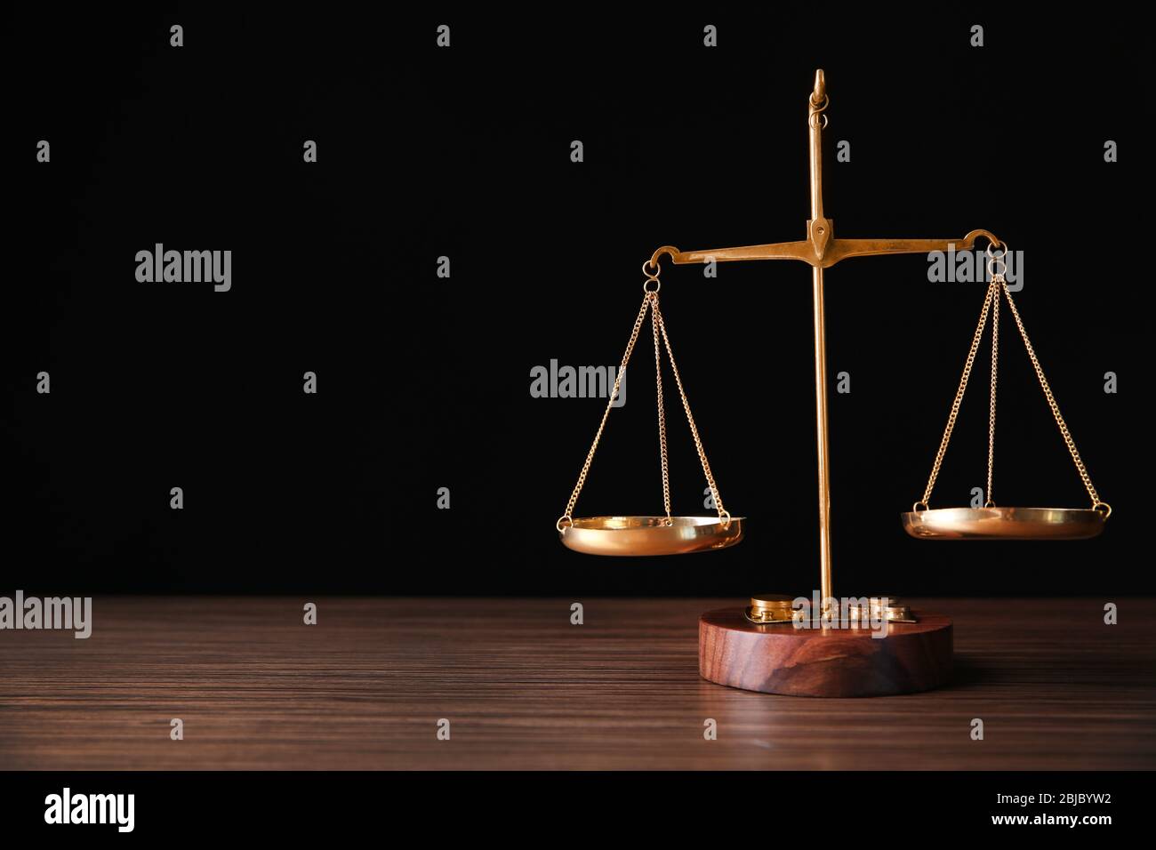 Justice scales on wooden table and black background Stock Photo - Alamy