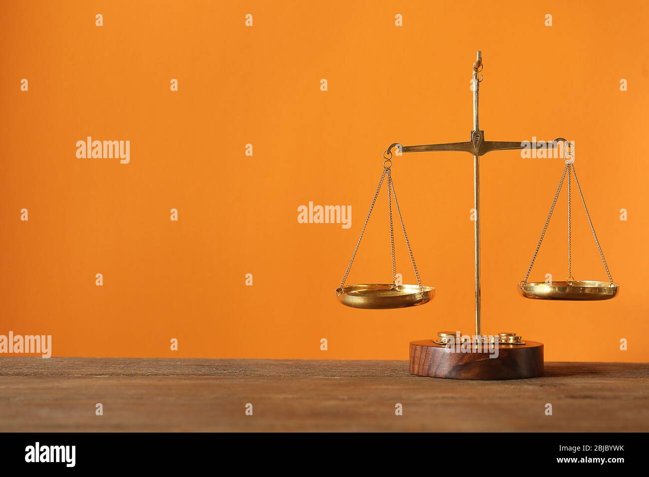 Justice scales on wooden table and orange background Stock Photo - Alamy