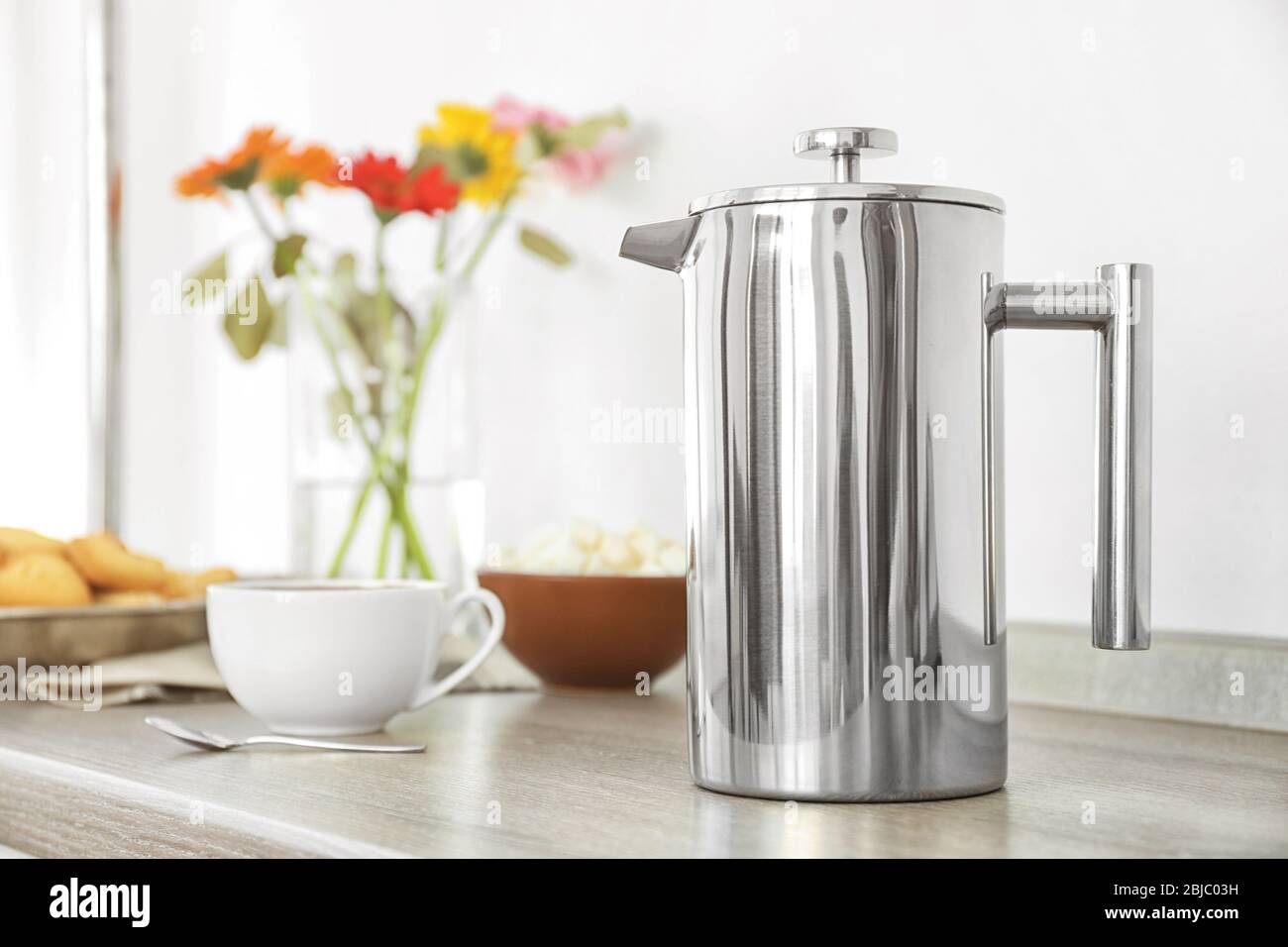 Coffee maker and breakfast with flowers on blurred background Stock Photo