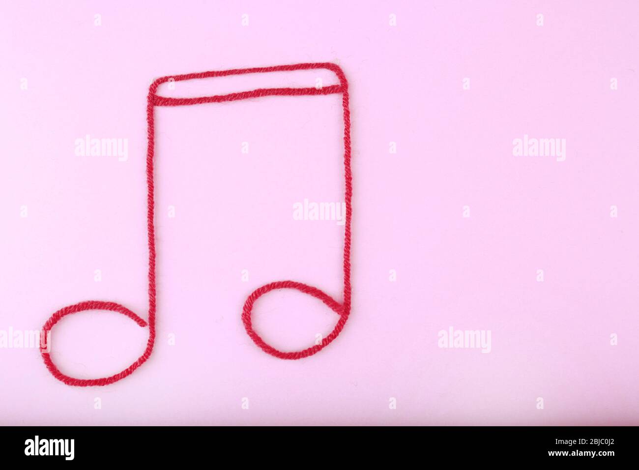 Music note sign made of rope on purple background Stock Photo - Alamy