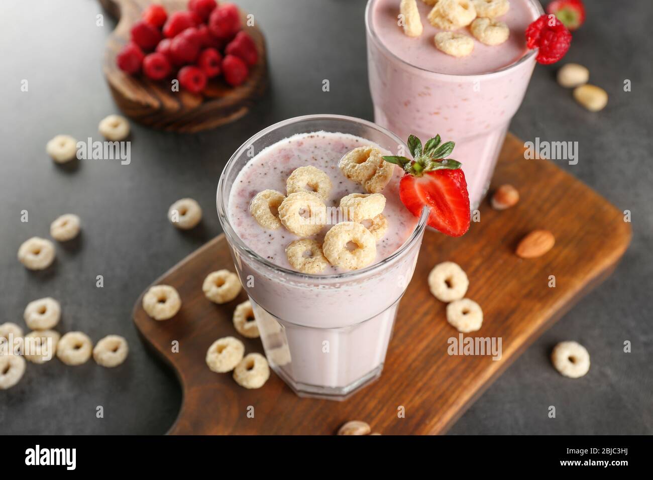 Fresh milkshake with strawberry on wooden cutting board closeup Stock Photo