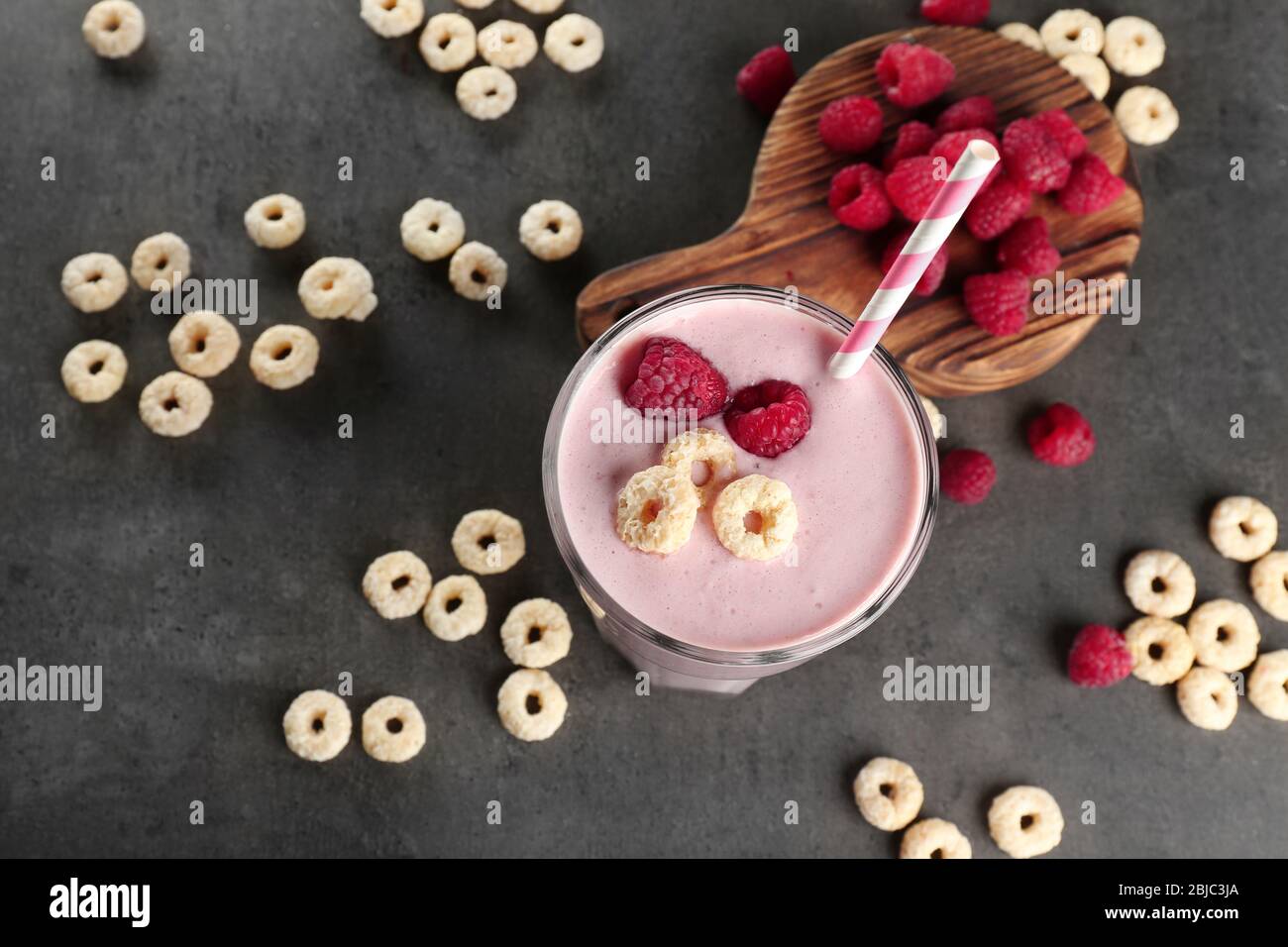 Fresh milkshake with raspberry on grey textured background Stock Photo