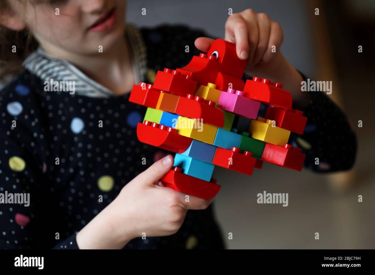 Chichester, West Sussex, UK - Isabelle, 8, pictured making and playing with a Coronavirus germ she made out of Lego Duplo whilst being homeschooled due to the Coronavirus (Covid-19) pandamic. Wednesday 29th April 2020 © Sam Stephenson / Alamy Live News. Stock Photo