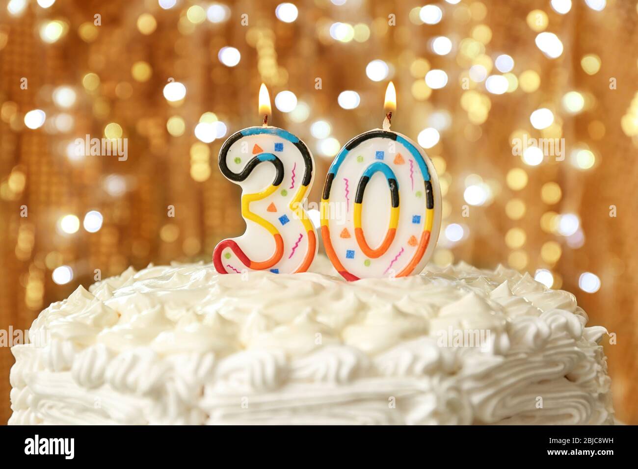 Birthday cake with candles on bokeh background Stock Photo - Alamy