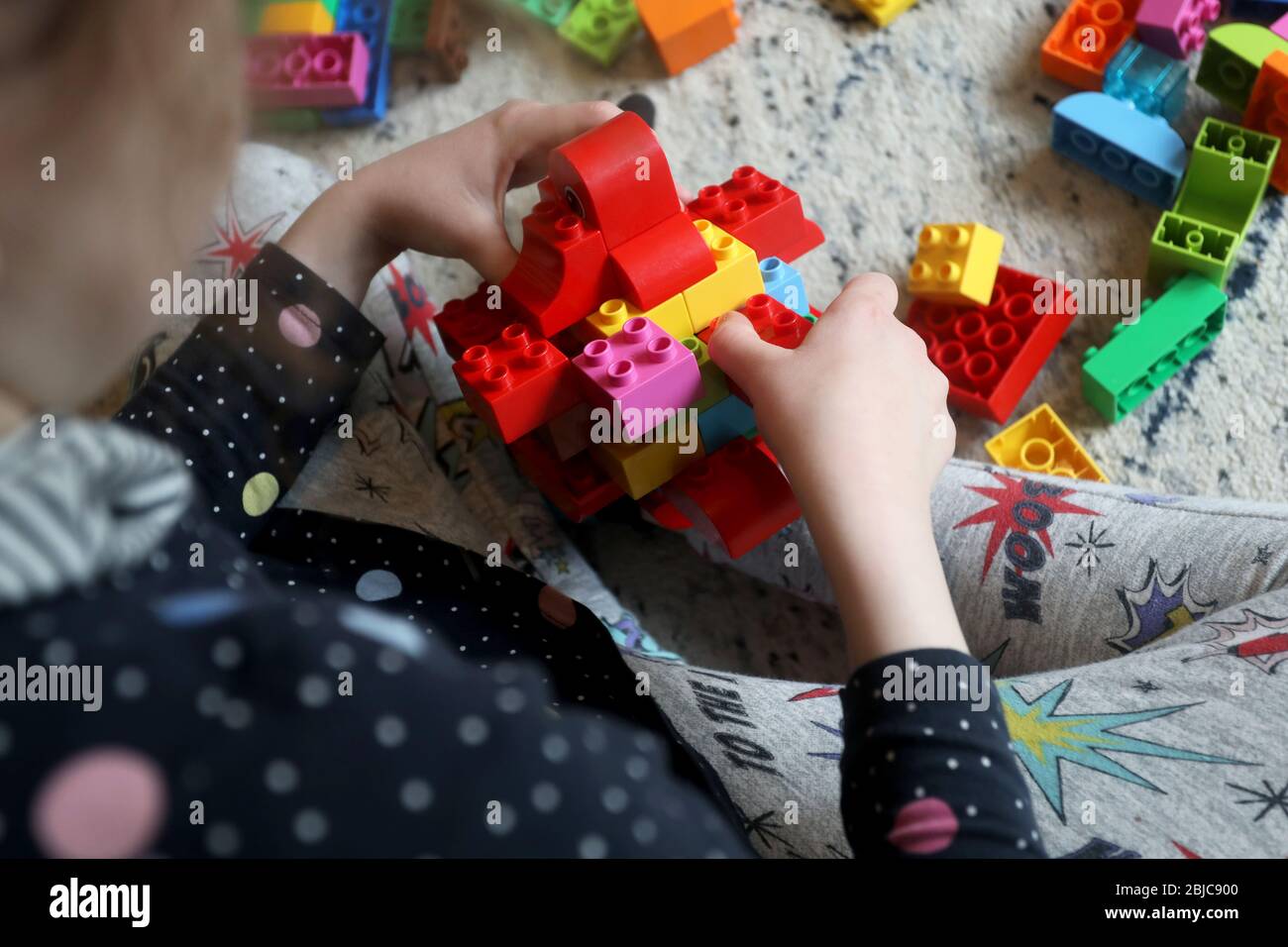 Chichester, West Sussex, UK - Isabelle, 8, pictured making and playing with a Coronavirus germ she made out of Lego Duplo whilst being homeschooled due to the Coronavirus (Covid-19) pandamic. Wednesday 29th April 2020 © Sam Stephenson / Alamy Live News. Stock Photo