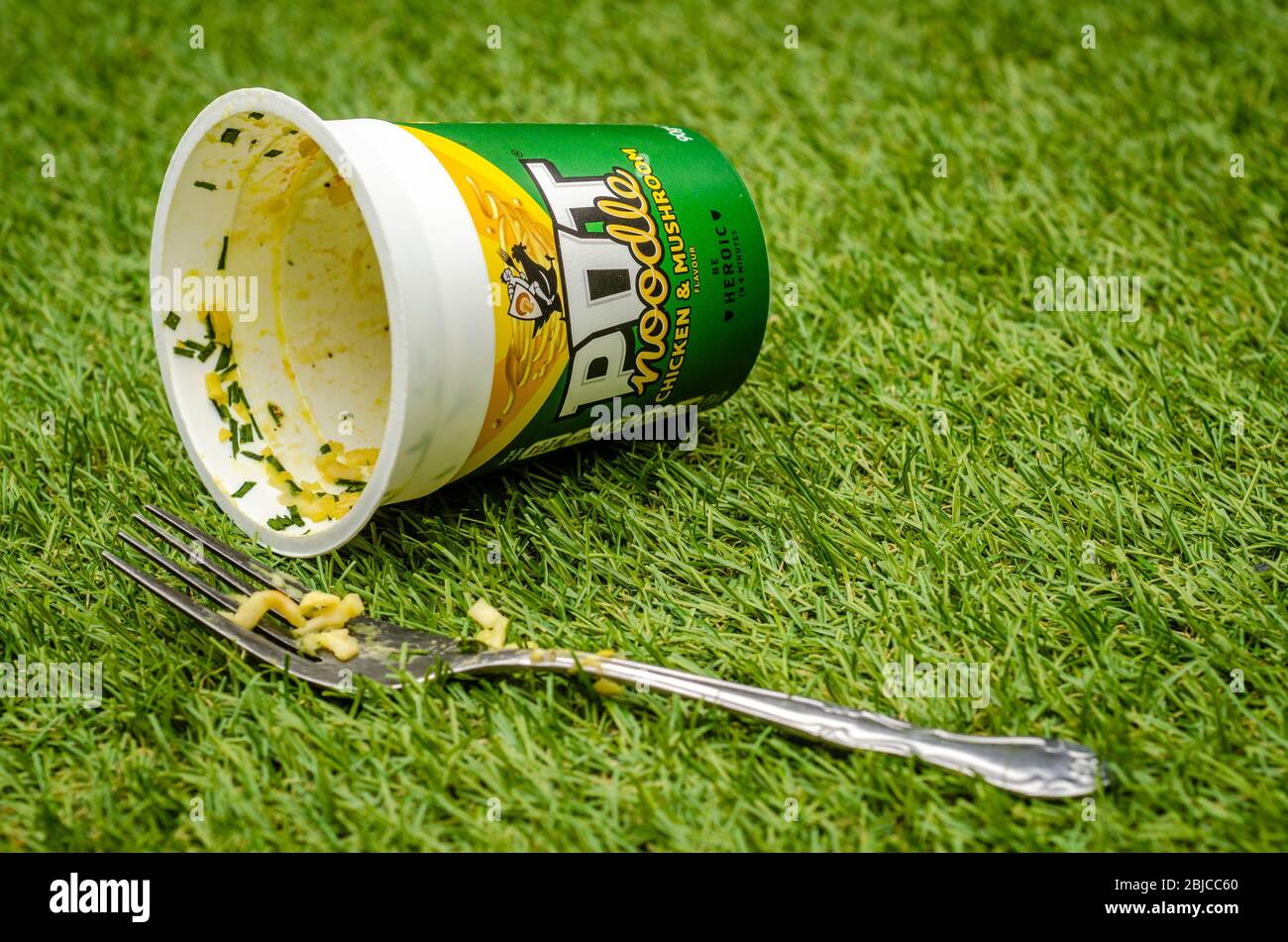 Empty and Discarded Pot Noodle Chicken and Mushroom Flavour Snack Pot, Isolated on a white background. Pot Noodle is made by Unilever Stock Photo