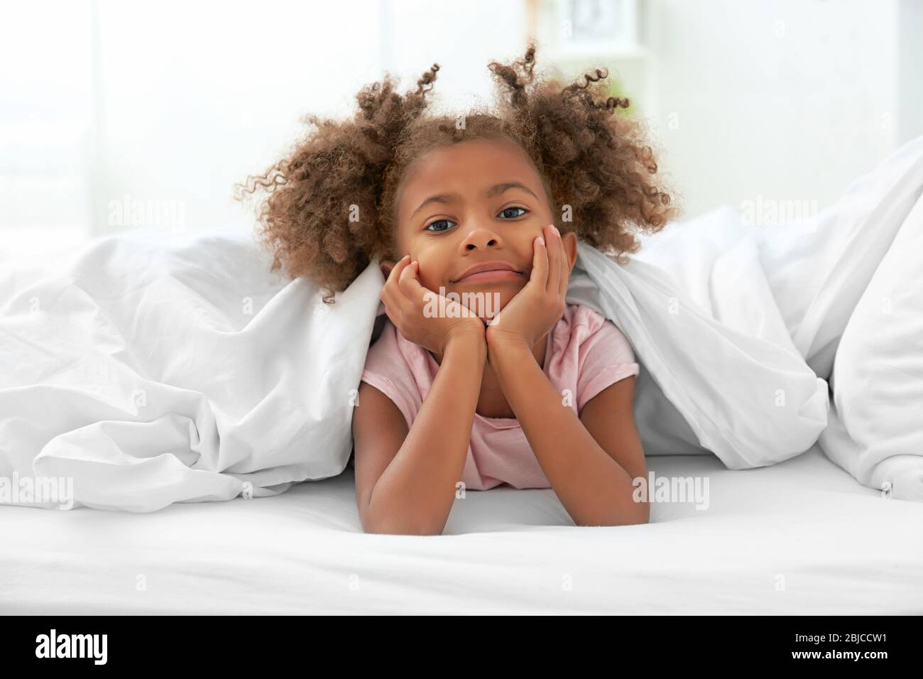 Little African American girl resting in bed Stock Photo - Alamy