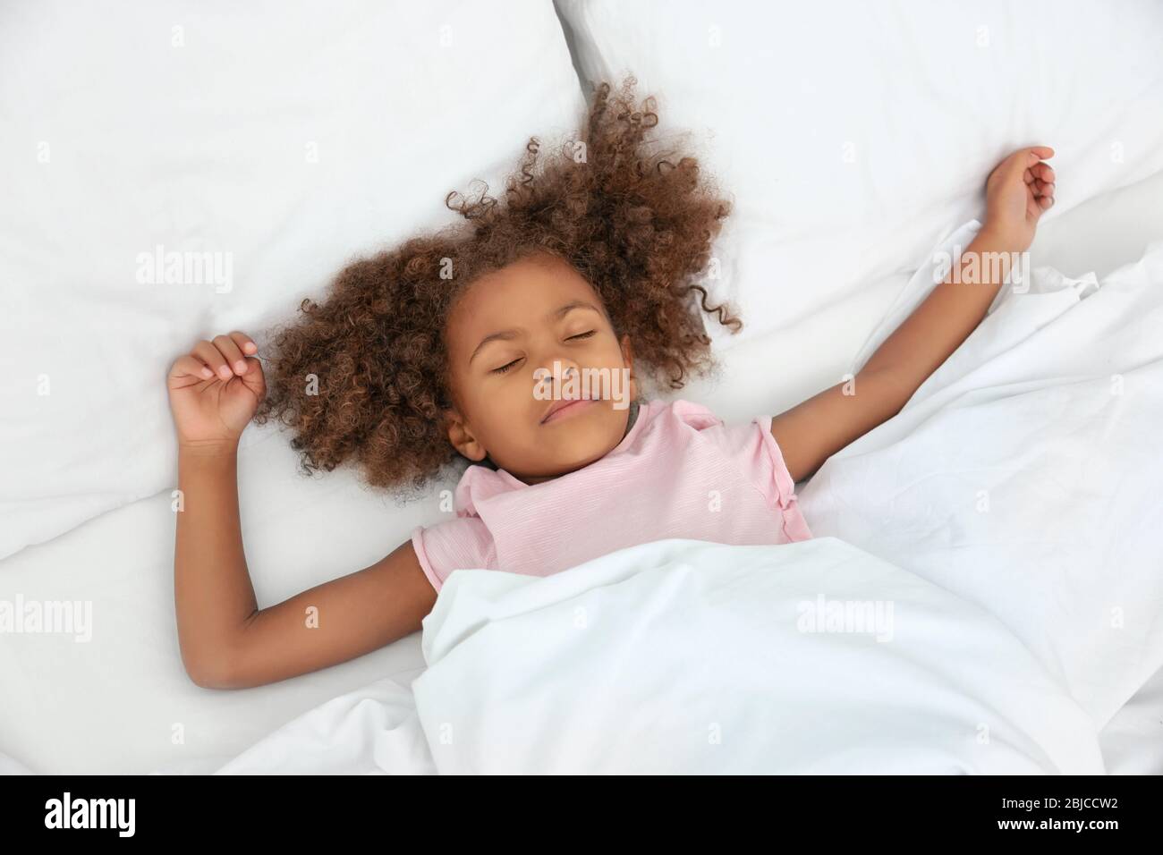 Little African American girl resting in bed Stock Photo - Alamy