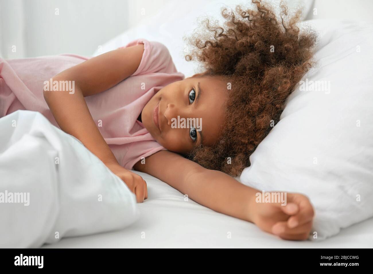 Little African American girl resting in bed Stock Photo - Alamy