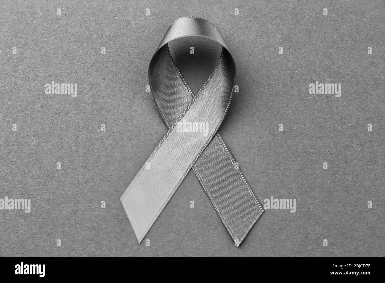 Grey ribbon on color background. Brain cancer, diabetes, asthma concept Stock Photo