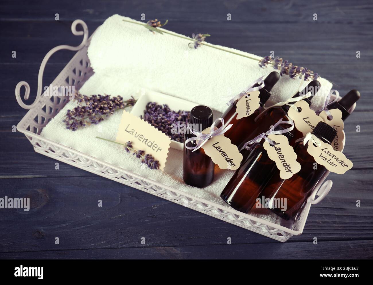 Fresh lavender flowers and bottles with oil on tray on wooden ...
