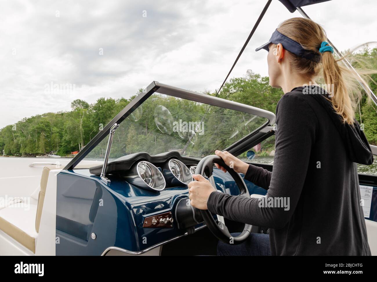 Young woman driving a motorboat Stock Photo