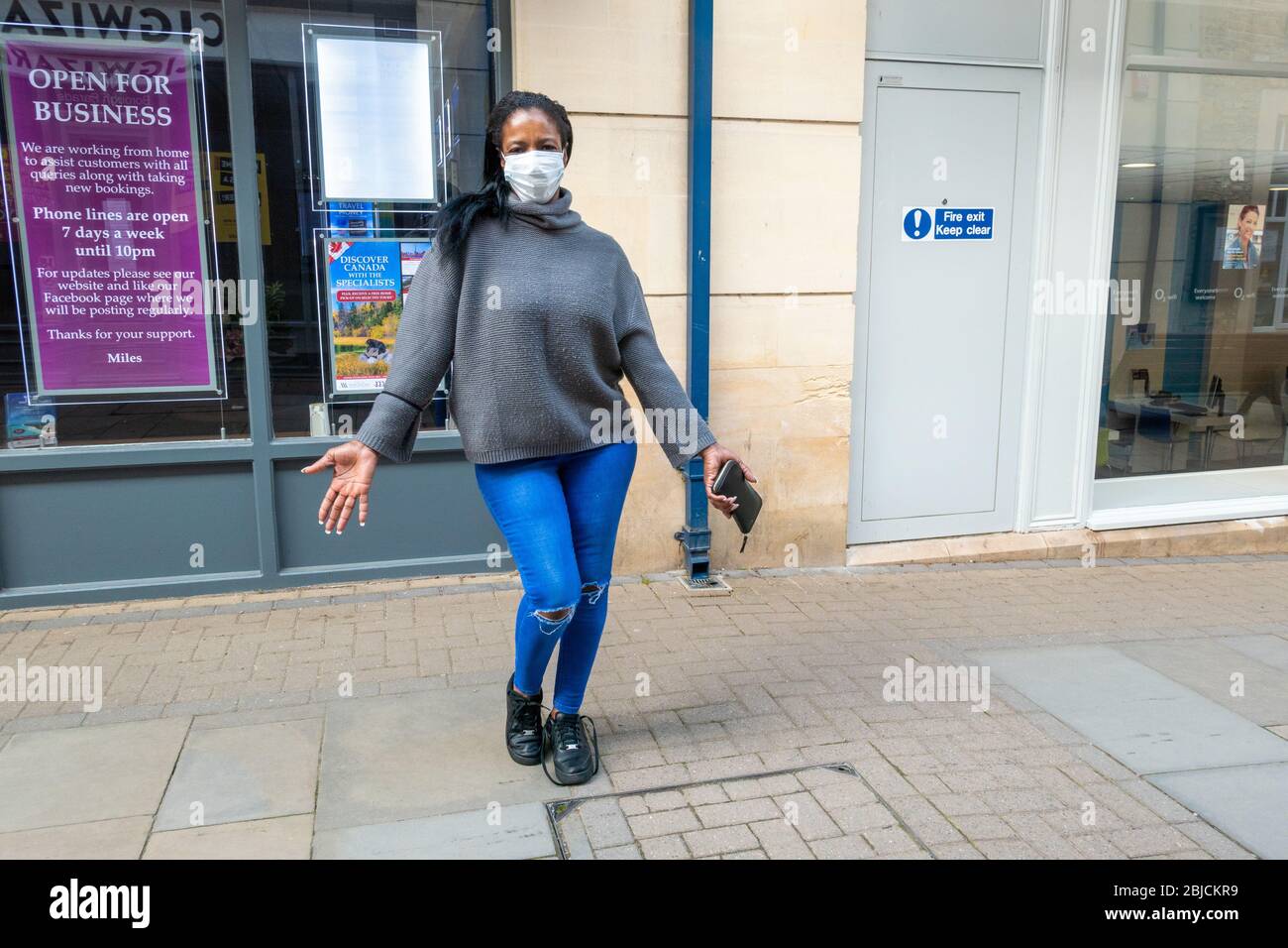 A woman poses in the street wearing a face mask Stock Photo