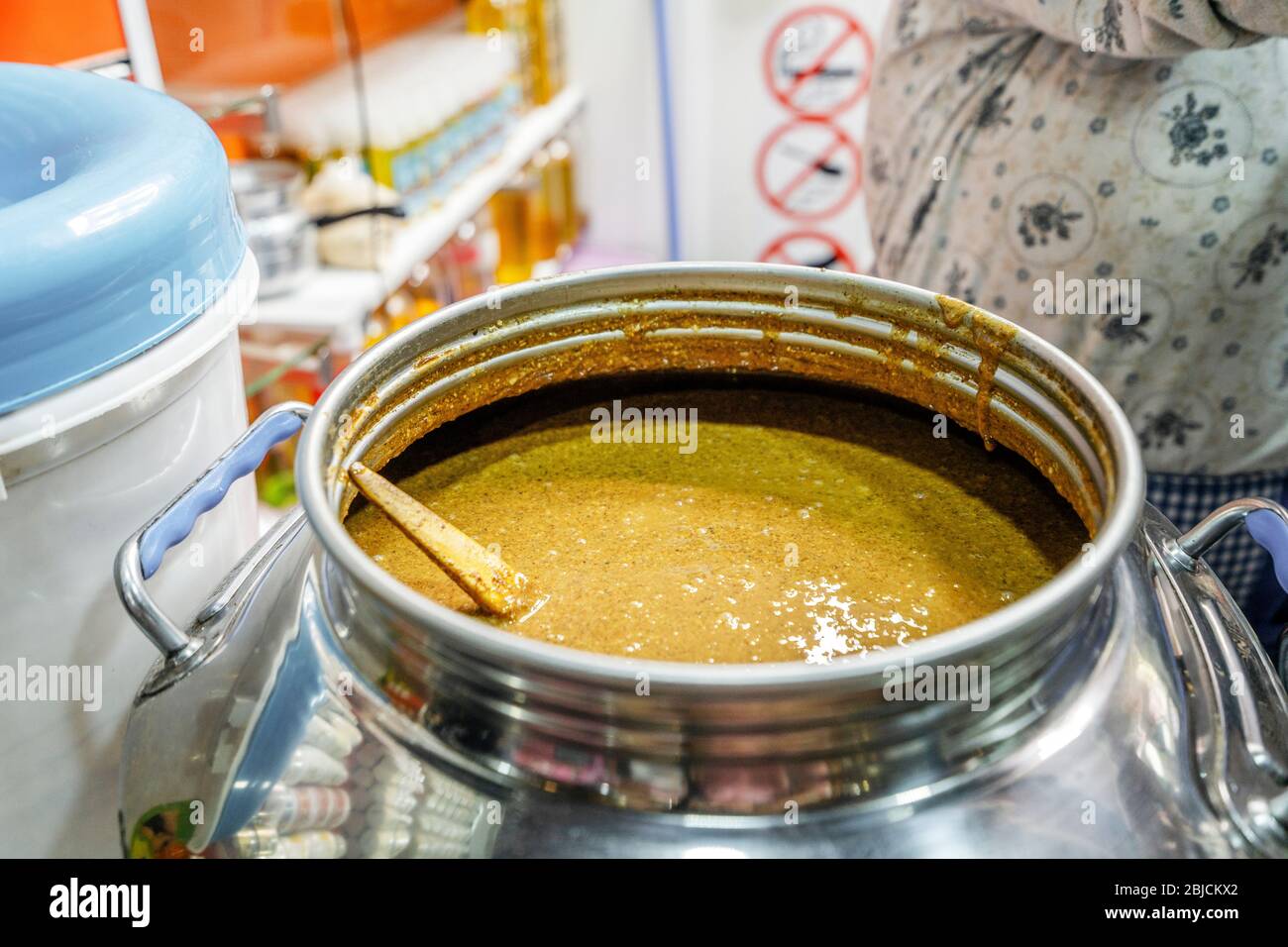 Silver pot full of freshly made organic peanut butter sold od Moroccan market in Agadir, Africa Stock Photo