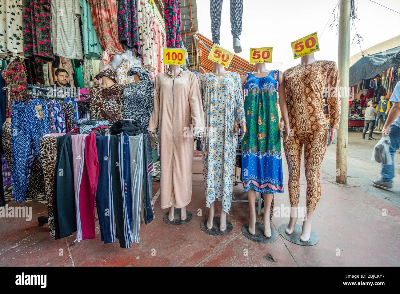 Agadir, Morocco - March 19, 2020: Colorful trousers, pajamas, night dresses and its arabic vendor on north African open air market Stock Photo