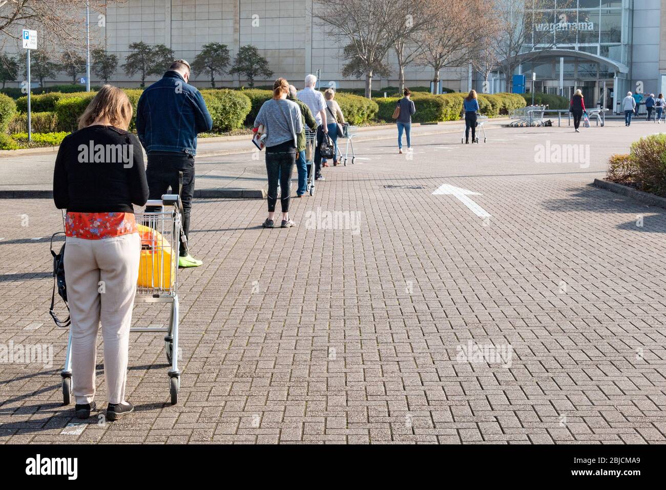 People wait in line in a queue for a supermarket during the coronavirus lockdown Stock Photo