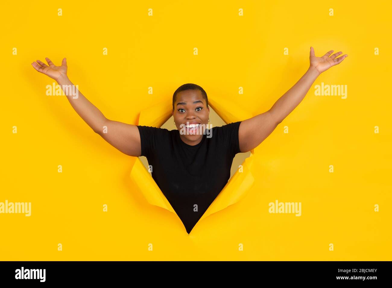 Happy Greeting Cheerful African American Young Woman Poses In Torn Yellow Paper Background Emotional Expressive Breaking On Breakthrought Concept Of Human Emotions Facial Expression Sales Ad Stock Photo Alamy