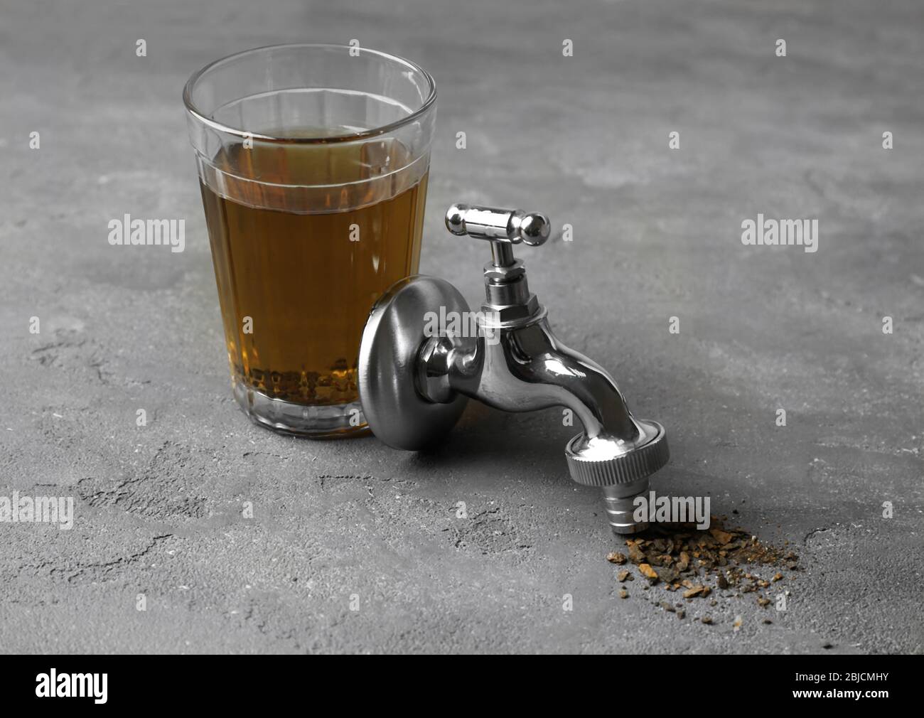 Faucet with glass of dirty water and rust flakes on gray textured background Stock Photo Alamy