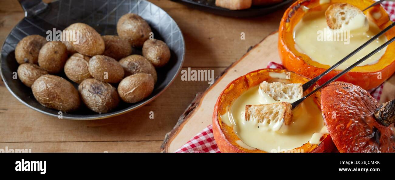 Servings of cheese fondue in pumpkin gourds viewed high angle on a