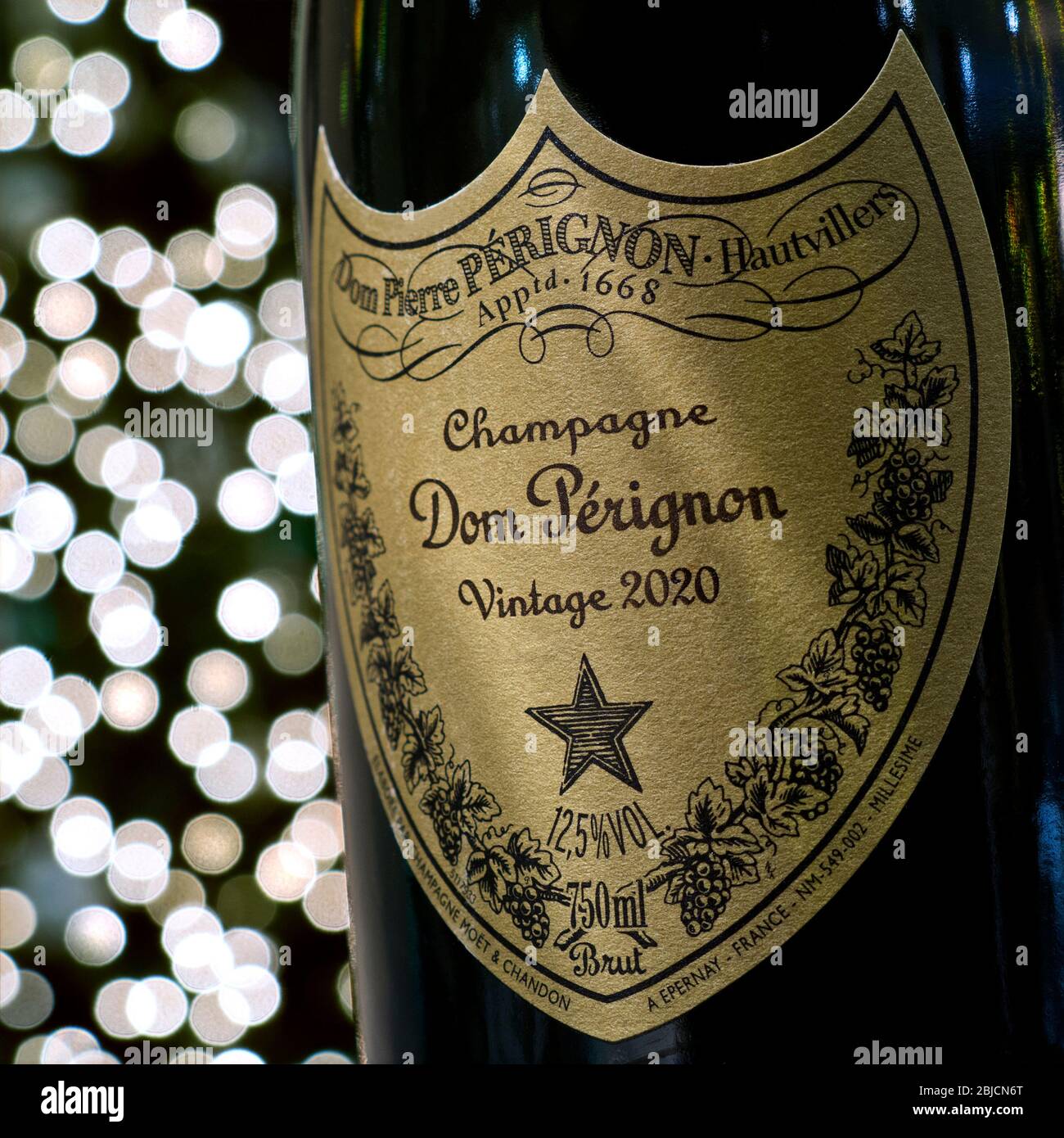 Dom Perignon Champagne bottle and label in party atmosphere with sparkling lights in background Concept label post-dated to Vintage  2020 celebration Stock Photo