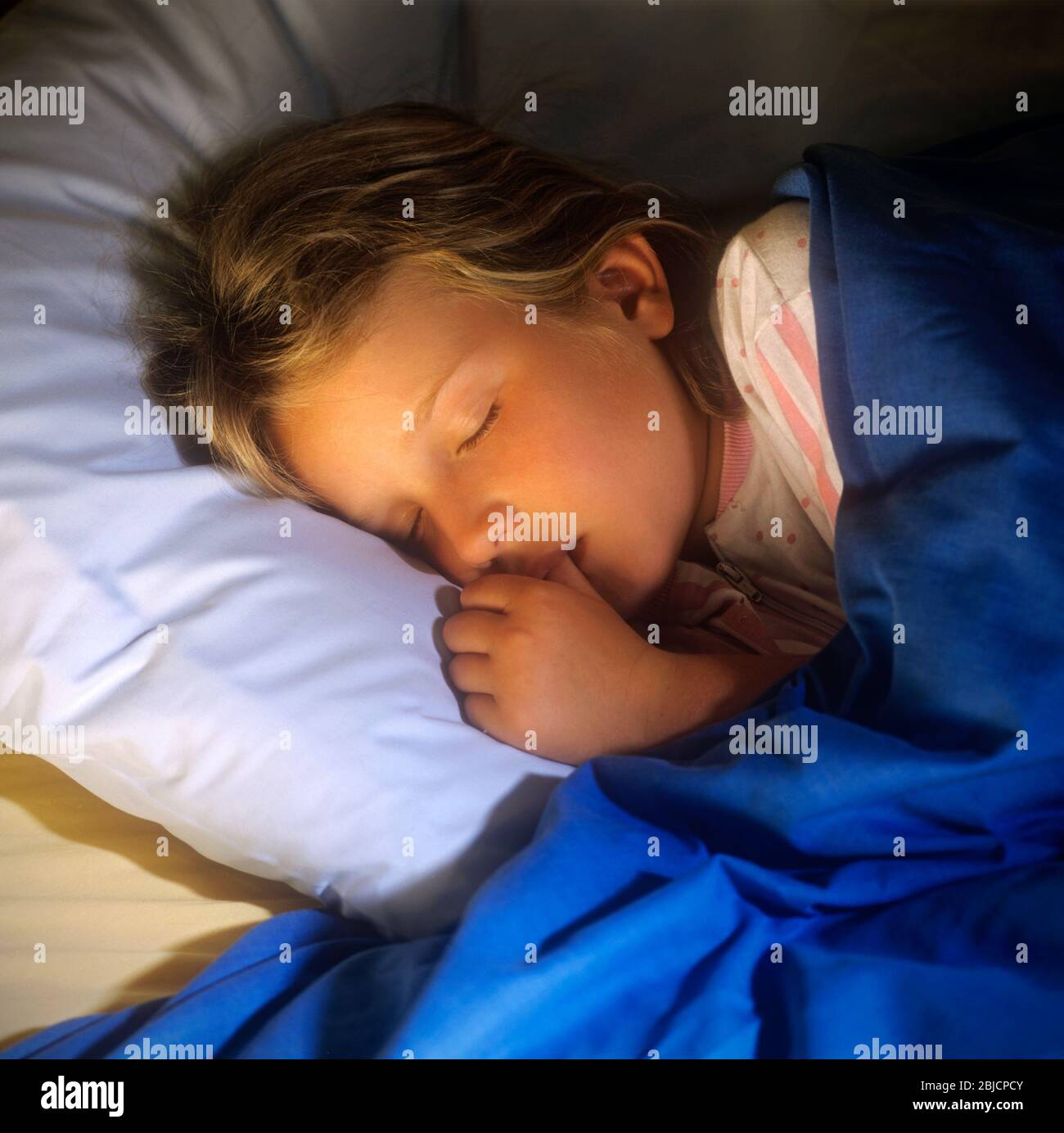 Young girl with head on pillow 6yrs 8yrs in bed hires stock photography and images Alamy