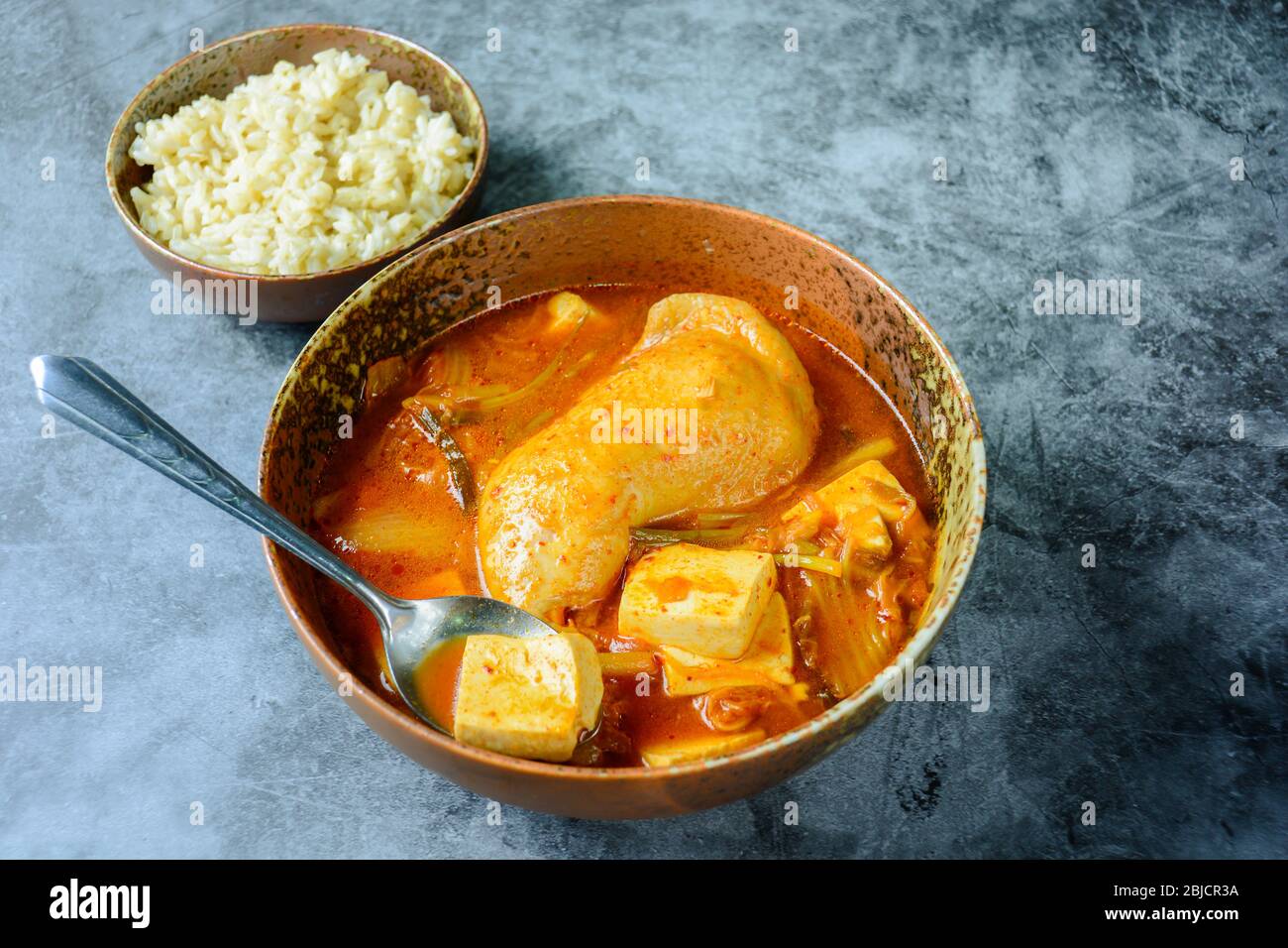 Korean traditional Kimchi soup with chicken and soft tofu Stock Photo