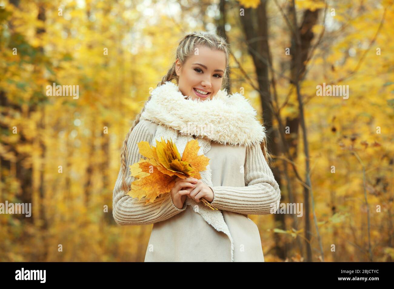 Beautiful girl with bunch of leaves in autumn park Stock Photo - Alamy