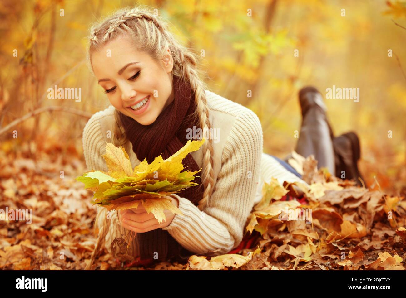 Beautiful girl with bunch of leaves in autumn park Stock Photo - Alamy