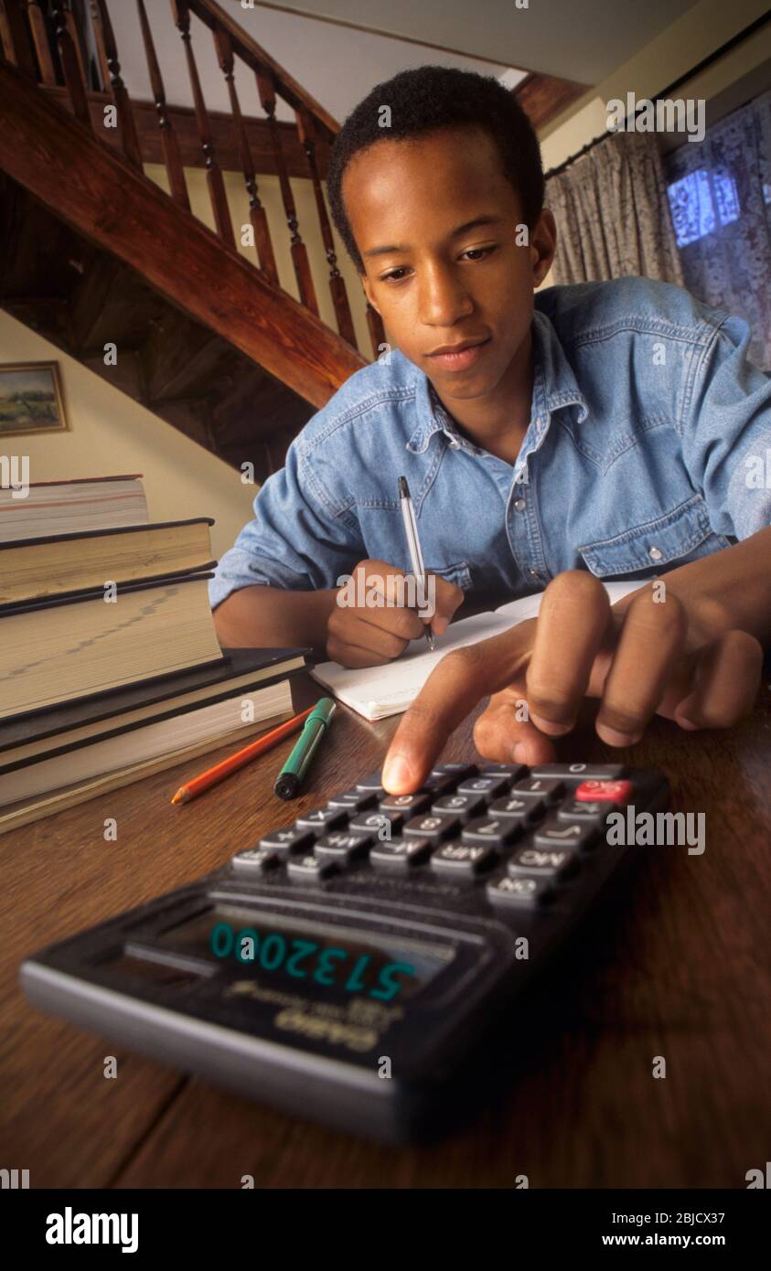 Teenager 14-16 years & calculator, handsome black African Caribbean school  boy student using traditional problem solving, concentrating on his  calculator at home for his school homework studies Stock Photo - Alamy
