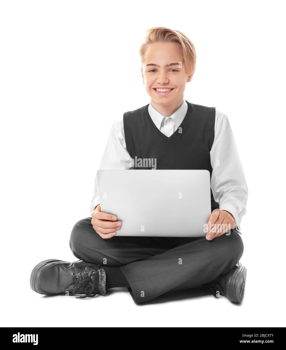 Teenage boy with laptop sitting on white background Stock Photo - Alamy
